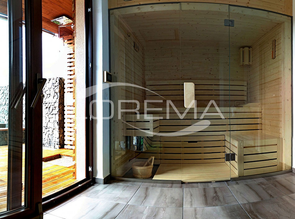 Finská sauna s prosklenou čelní stěnou vyrobená na zakázku, provedení severský smrk, ovládání LOREMA Welllness s dotykovým displejem