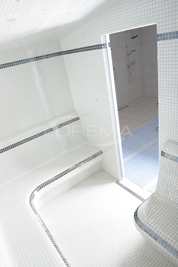 Interiér je obložen bílou skleněnou mozaikou Ezarri Pearl Alba se zvýrazněním konstrastními pruhy Metal Lava